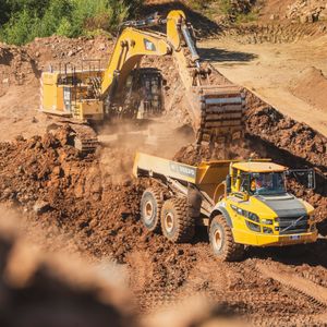 A Caterpillar excavator loading a Volvo articulated dumptruck