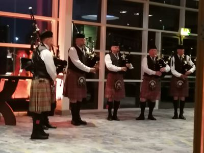 Six bagpipers in traditional highland dress playing at the Institute of Quarrying Dinner Dance