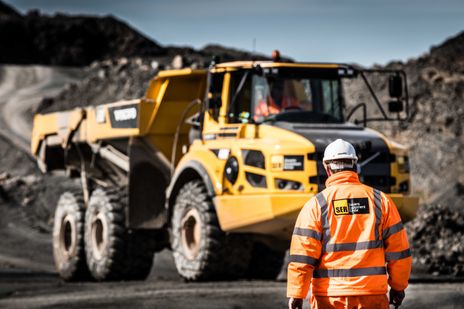 SER employees on site in hardhats and orange high-viz with a Volvo articulated dump truck.